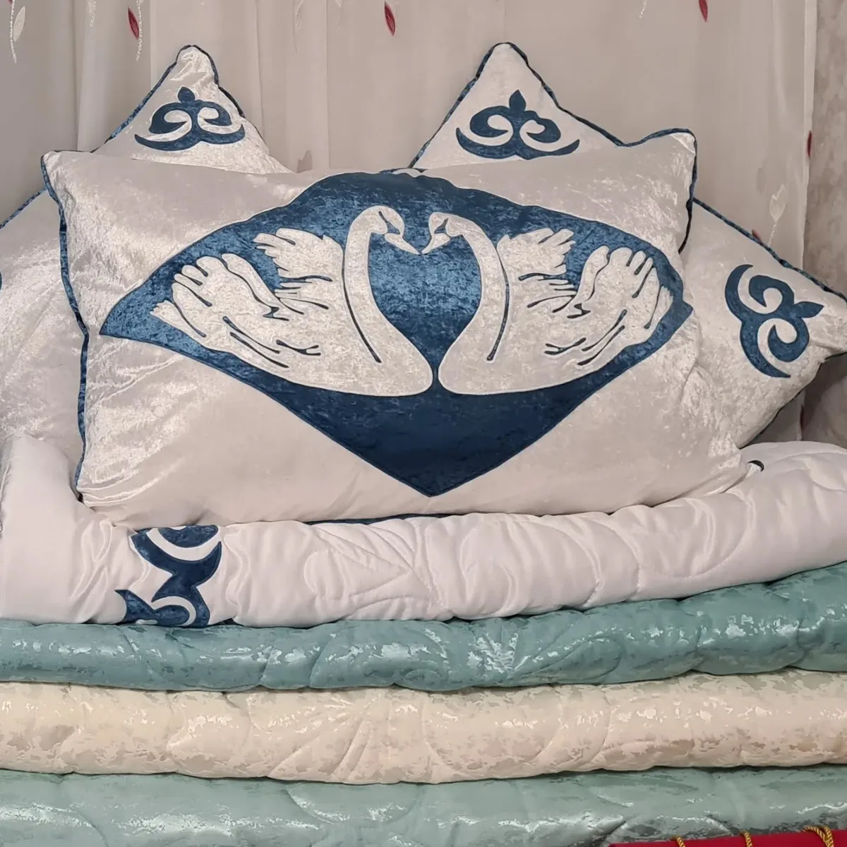 Xan Kyzy signature swan-motif bridal bedding styled on a bed